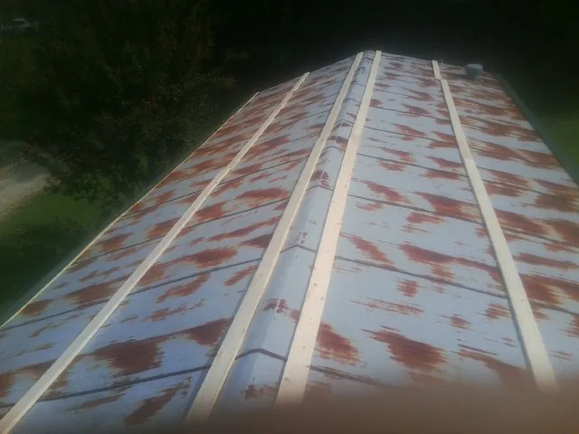 Rusted metal roof panels with new wood purlins before replacement — Storm Damage Roof Repair in Hickory Valley by Roofing Brothers