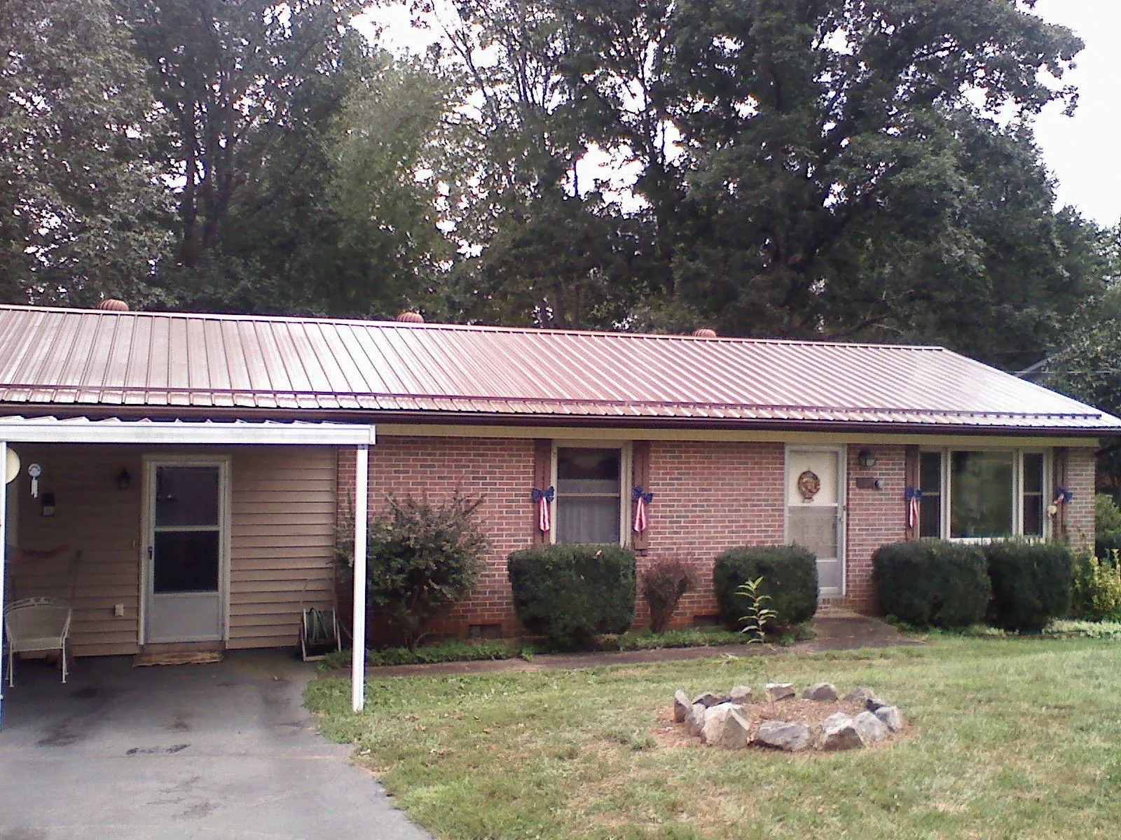 Bronze metal roof and carport on a brick ranch home — Roof Repair work by our crew in Hickory Valley