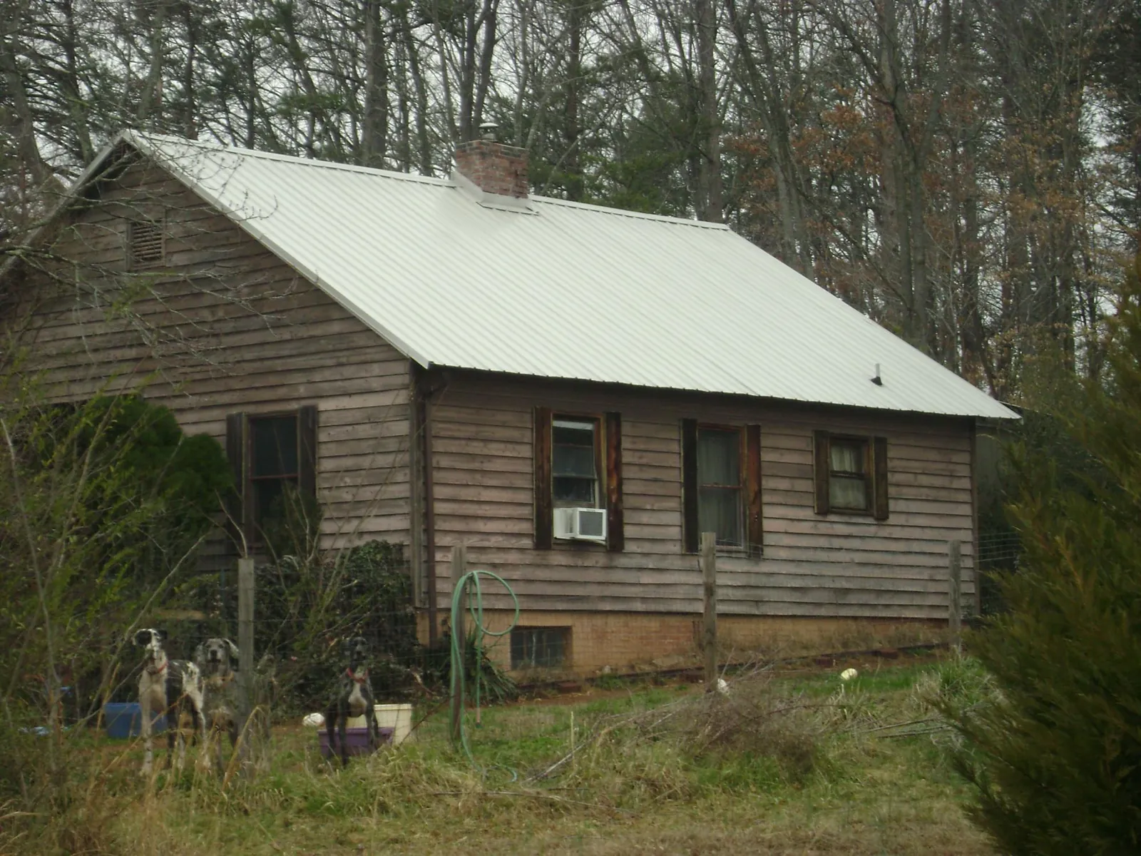 White metal roof on an old wood sided farmhouse, from a Metal Roof Installation job in Hickory Valley